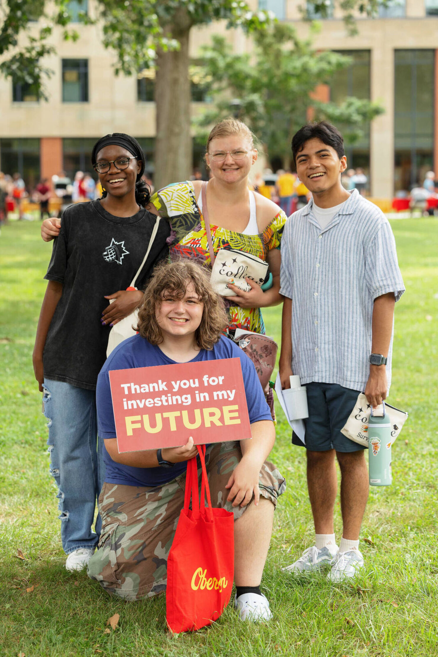 students smiling on campus lawn
